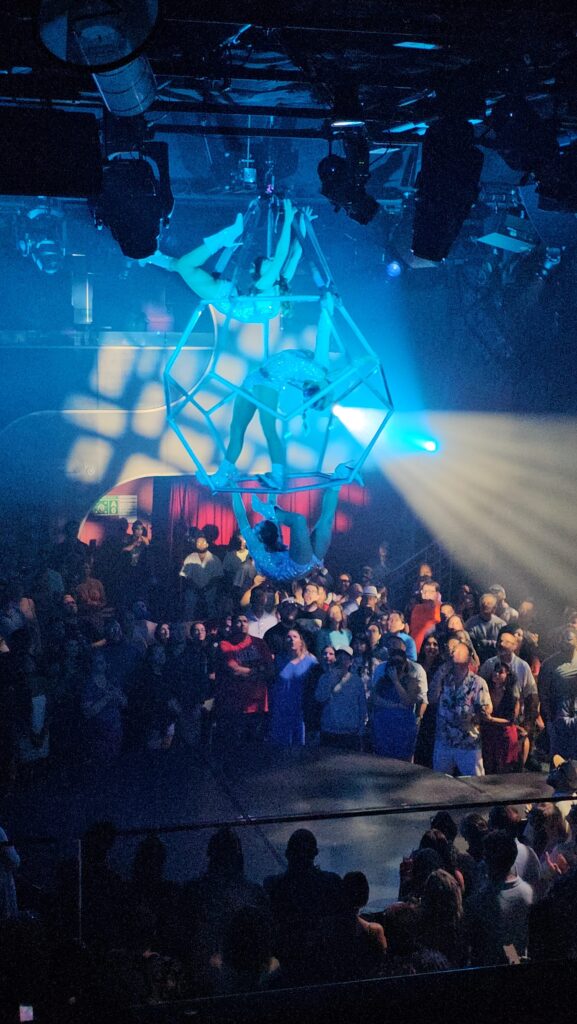acrobats suspended in air during a performance on a cruise ship scarlet lady virgin voyages persephone show